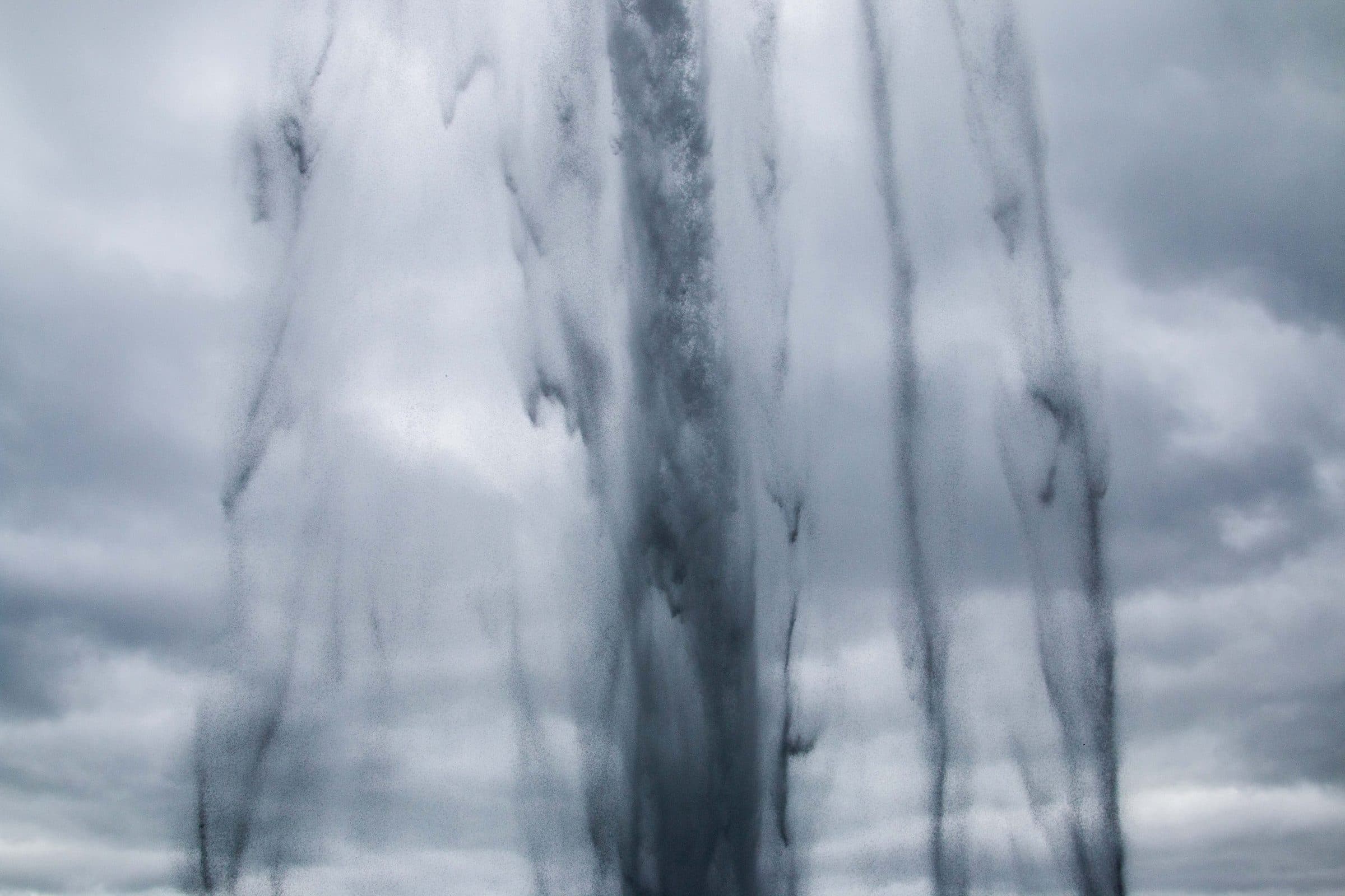 Streams of falling water against a cloudy sky, fine art photograph by Jason Bowman