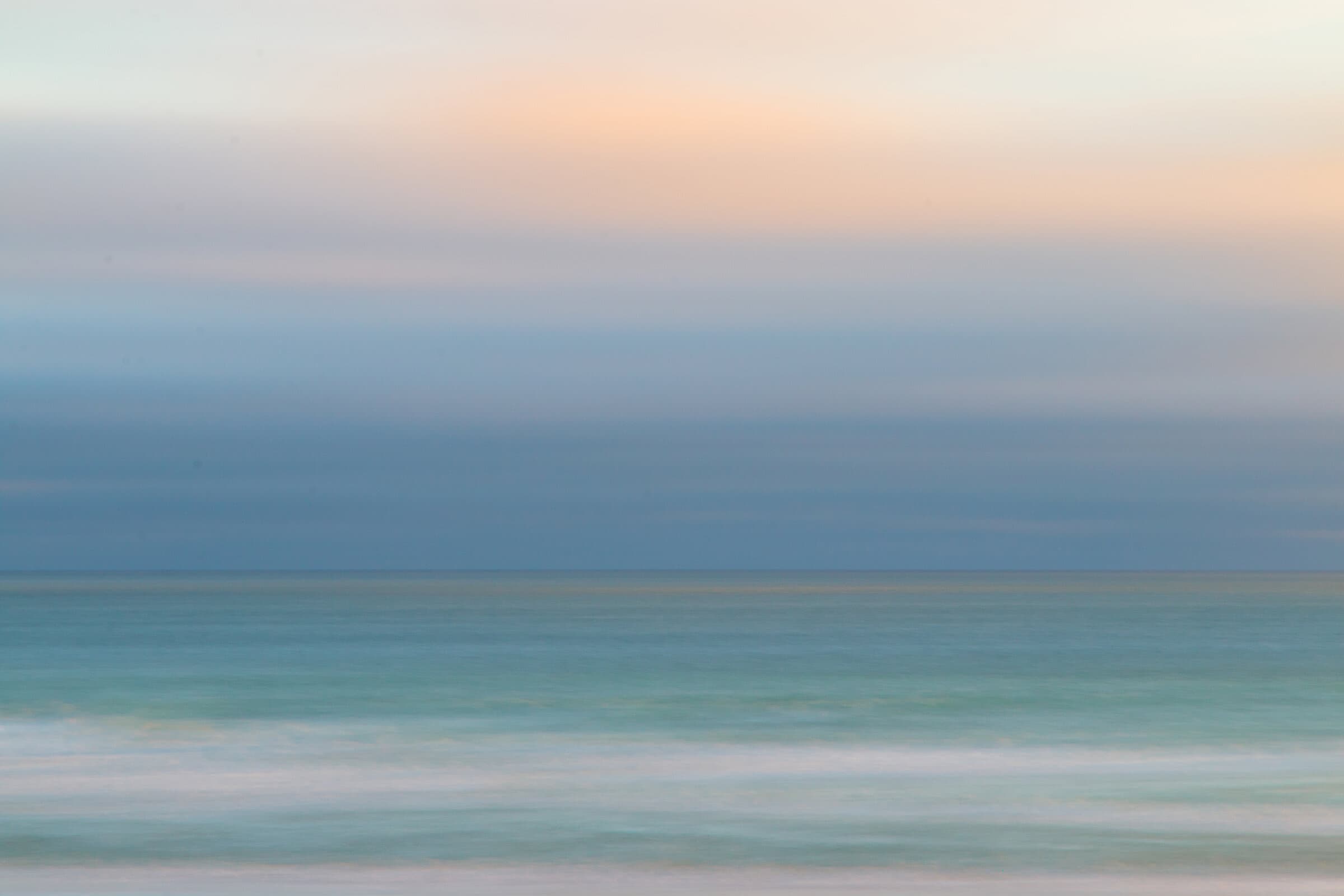 Pale sunset colors over the ocean horizon, fine art photograph by Jason Bowman