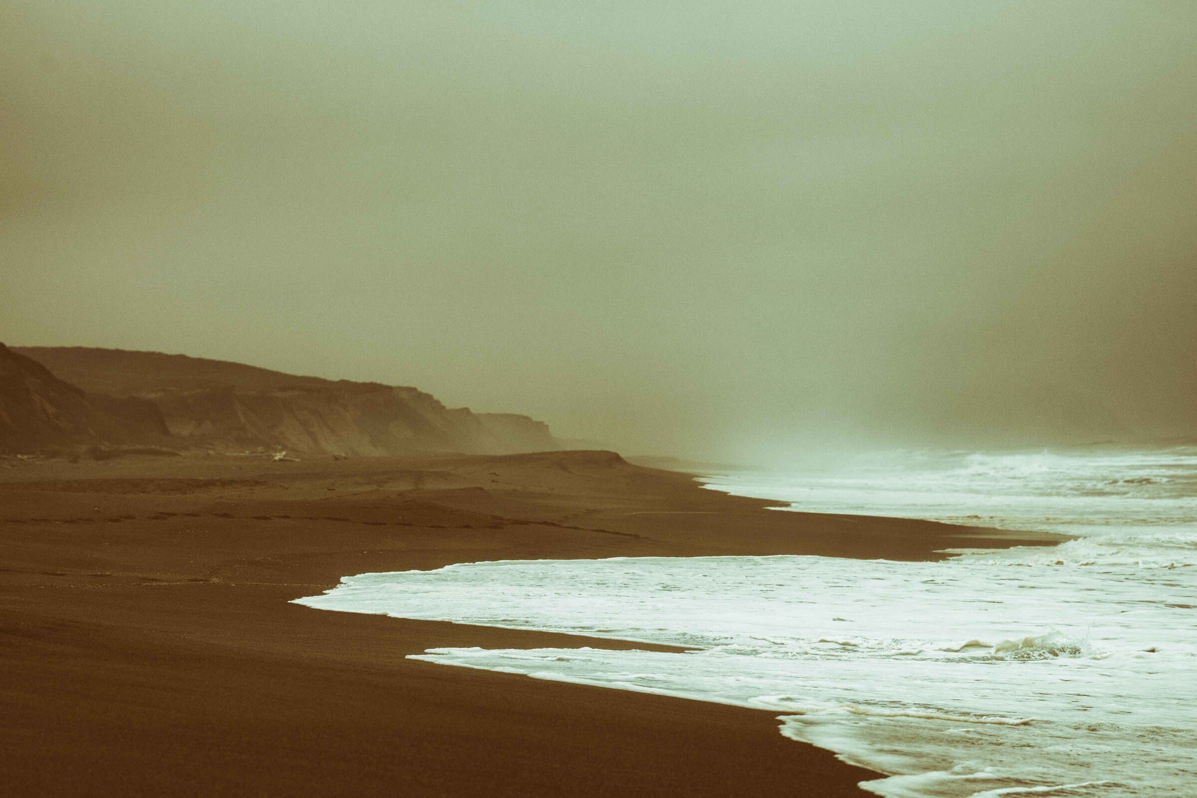 Sepia-toned beach cliffs and waves, fine art photograph by Jason Bowman