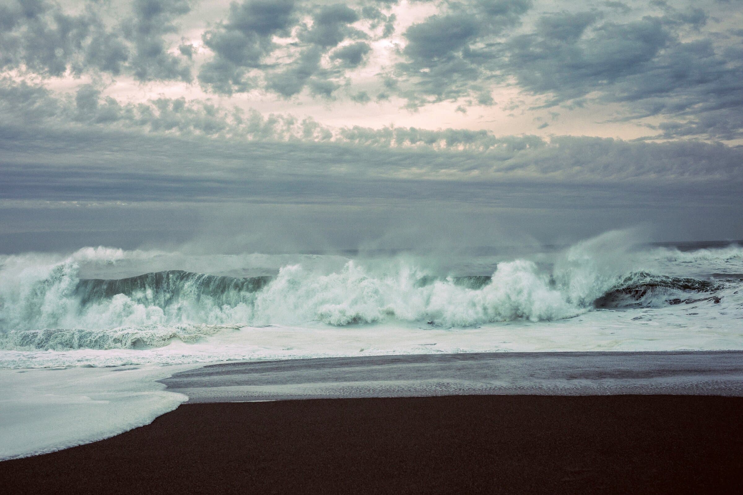 Stormy waves breaking on a black sand beach, fine art photograph by Jason Bowman