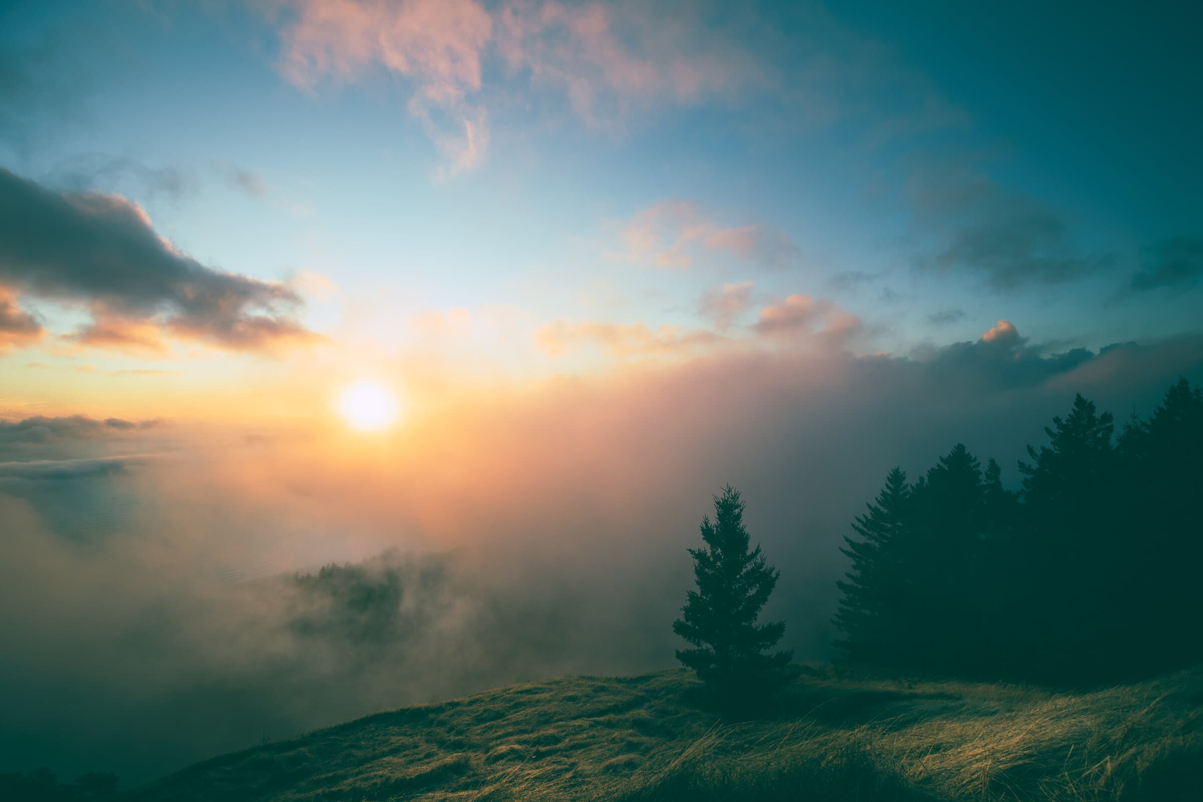 Sunset clouds over a tree-lined hillside, fine art photograph by Jason Bowman